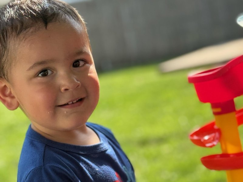 Smiling toddler playing outside in the yard